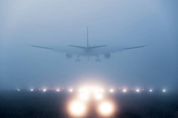 flugzeug landet im nebel - landen stock-fotos und bilder