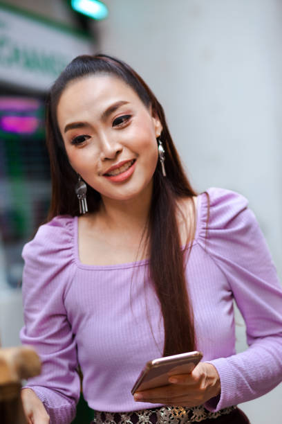 istock Thai woman passing shop with mobile in hand 1179112089