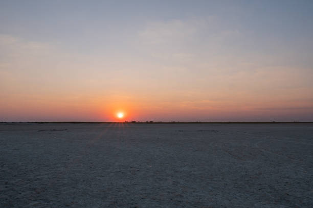 Sunset in Makgadikgadi Salt Pan - Horizon at Romantic Dusk - Empty Flat Plain, Colorful Sky at Twylight with Setting Sun