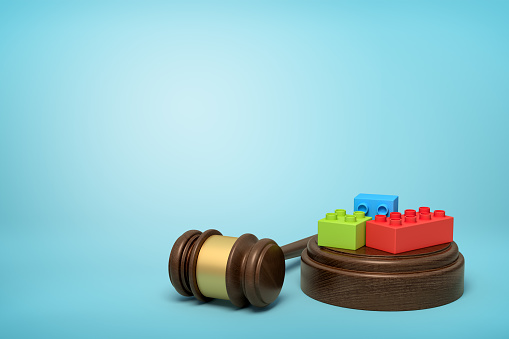 3d rendering of colorful pieces on round wooden block and brown wooden gavel on blue background. Digital art. Objects and materials. Toys and games.