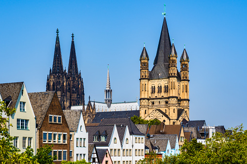 Cologne, North Rhine Westphalia, Germany: Skyline of the old town with solorful houses rooftops, the tower of the Cologne gothic cathedral and the tower of Gtreat St. Martin church.