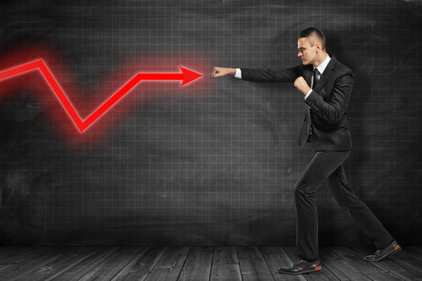 istock Businessman hitting red diagram arrow on black background 1179120447