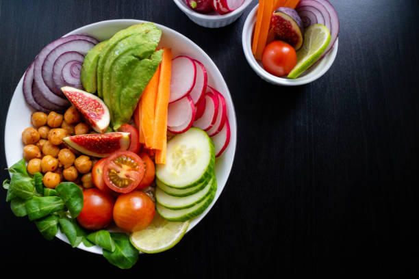 istock Buddha bowl made with fresh ingredients such as avocado, figs, carrot and lime. Top view on dark background. 1179122252