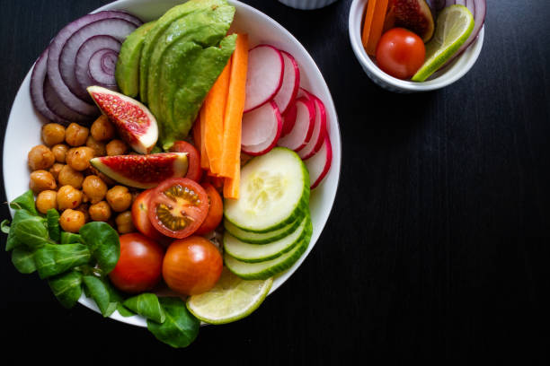 istock Vegetarian Buddha bowl on a white plate with figs, avocado, chickpeas and other fresh vegetables. Top view. 1179123398