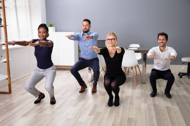 istock Young Businesspeople Doing Sit-ups In Office 1179124734