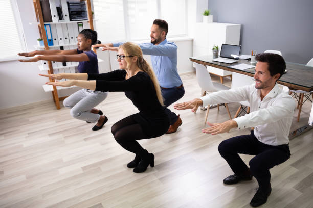 istock Young Businesspeople Doing Sit-ups In Office 1179124737