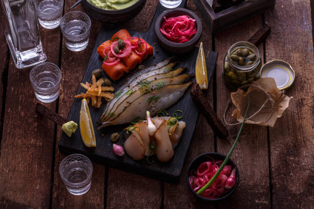 istock Assorted preserved fish on dark cutting board with vodka shots. 1179124917