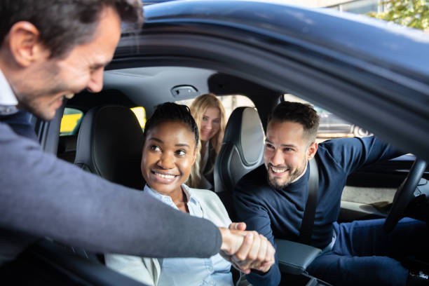 hombre sacudiendo hanks con amigos sentados en el coche - car pooling fotografías e imágenes de stock