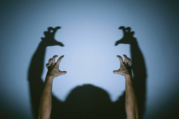 istock shadow of evil hands on the wall. halloween prank 1179126014