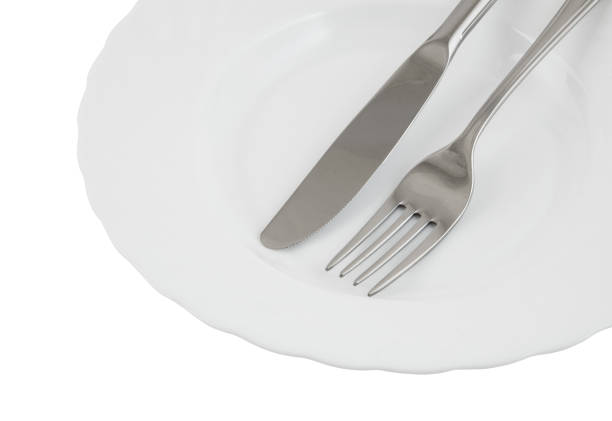 istock Close up of knife and fork in plate isolated 1179126018