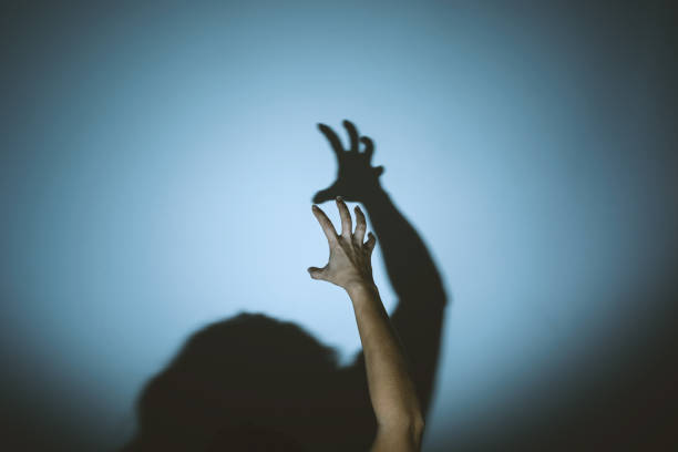 istock shadow of evil hands on the wall. halloween prank 1179127602
