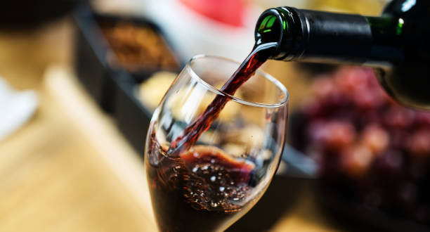 czerwone wino wlewa się do kieliszka do wina na degustacji z różnych rodzajów przekąski. - red wine zdjęcia i obrazy z banku zdjęć