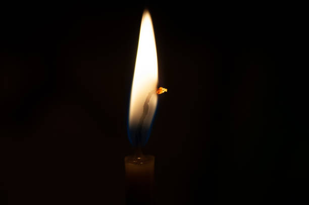istock One candle flame at night closeup - isolated, macro 1179130189