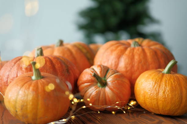 istock pumpkins with a shining garland on a wooden table 1179133282
