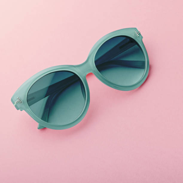 istock Classic oval oversized sunglasses closeup toned in mint color on pink background 1179136078