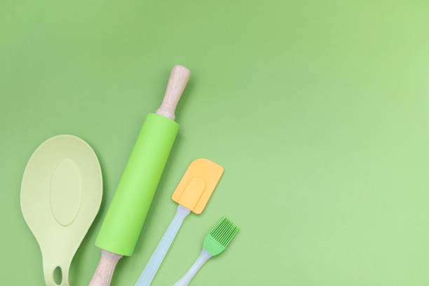 istock Kitchen silicone utensils for baking and cooking any dishes. Rolling pin, spatula and culinary brush on green background with copy space. Flat lay. 1179139430