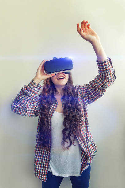istock Smile young woman wearing using virtual reality VR glasses helmet headset on white background. Smartphone using with virtual reality goggles 1179139730