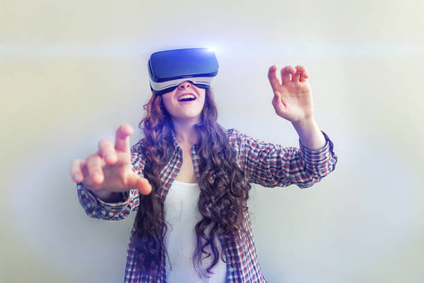 istock Smile young woman wearing using virtual reality VR glasses helmet headset on white background. Smartphone using with virtual reality goggles 1179139751