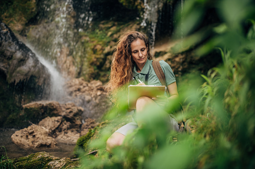 Female Biologist Examining Plants and Vegetation in Nature