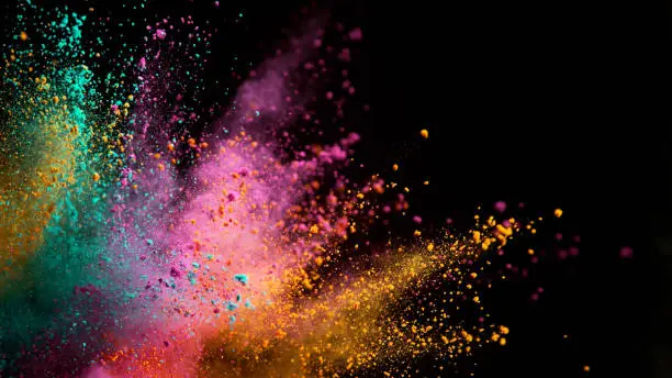 Photo of Explosion of colored powder on black background