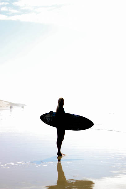 istock Women on the beach with surfboard 1179146562