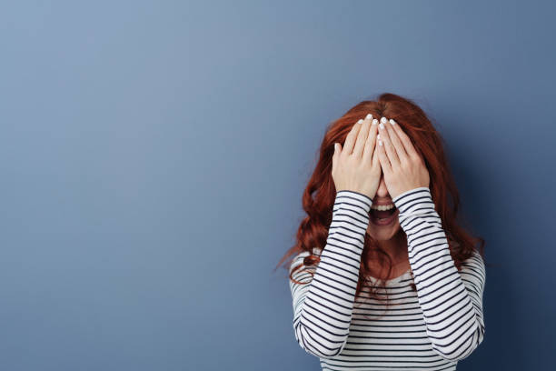 istock Laughing young woman covering her eyes 1179146837
