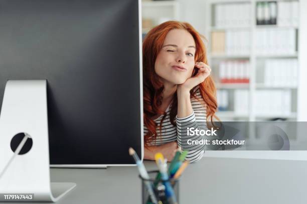 Playful Young Businesswoman Winking At The Camera Stock Photo - Download Image Now - Office, Occupation, Fun