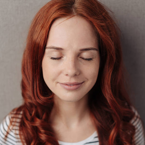 Serene young woman with closed eyes stock photo