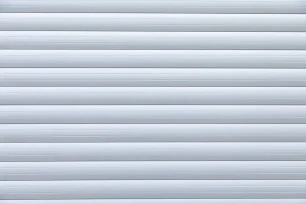 Close-up of white metal striped roller-shutter door