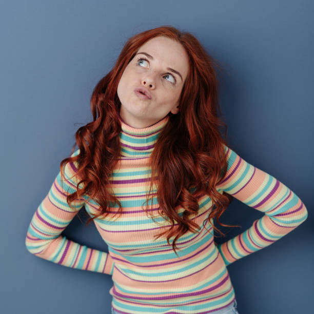 istock Cute young woman deep in thought 1179150425