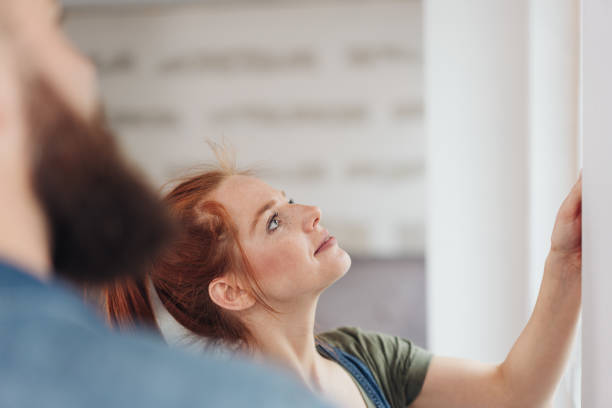 istock Young woman checking a newly painted white wall 1179153139