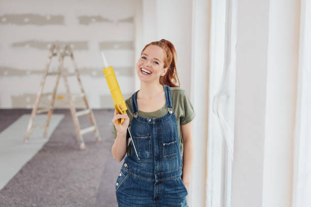 istock Laughing young woman holding a glue gun 1179155099