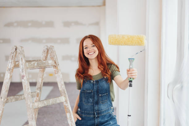 istock Capable happy young woman holding up paint roller 1179155649
