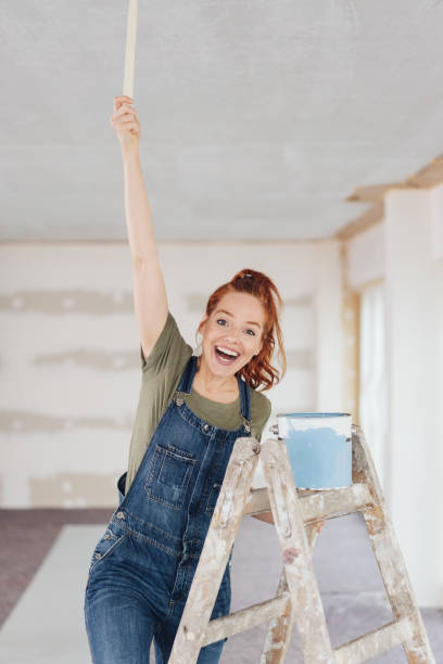istock Exultant young woman cheering during renovations 1179157307