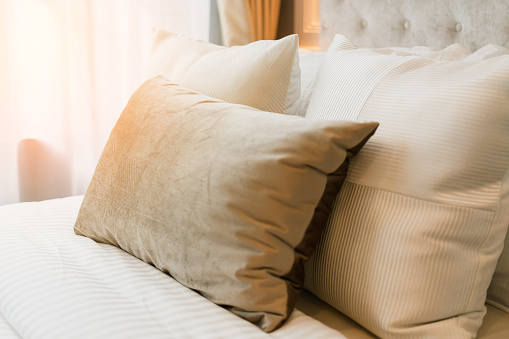 Bed maid-up with clean white pillows and bed sheets in beauty bedroom. Close-up. interior background