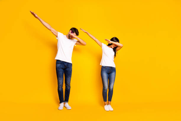 Full body photo of two people dancing at theme party cool modern moves wear casual clothes isolated yellow color background Full body photo of two people dancing at theme party cool modern, moves wear casual clothes isolated yellow color background dab dance photos stock pictures, royalty-free photos & images
