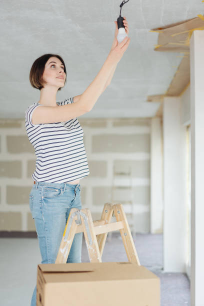 istock Young woman changing a light bulb 1179159707