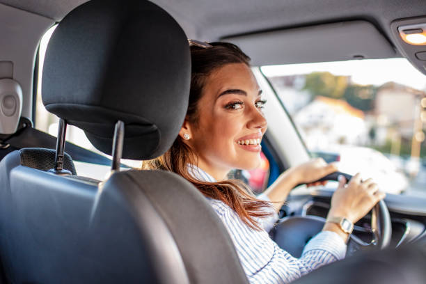 istock Smiling woman sitting in a car and looking back. 1179159775