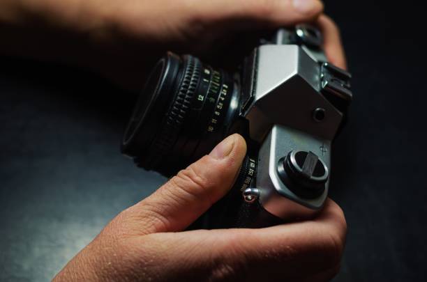 istock Old film camera in male hands. 1179159837