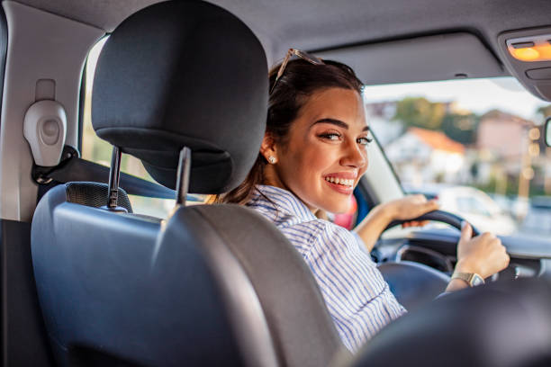 istock Smiling woman sitting in a car and looking back. 1179159930