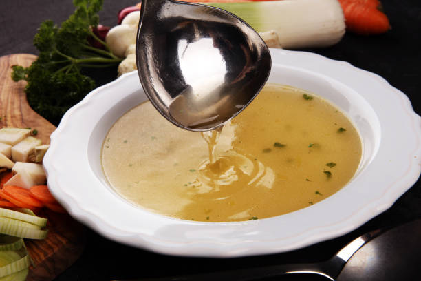 istock Broth with carrots, onions various fresh vegetables in a pot - colorful fresh clear spring soup. Rural kitchen scenery vegetarian broth 1179159998