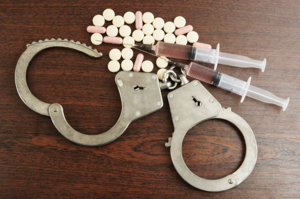 istock Handcuffs, drugs and syringes 1179160192