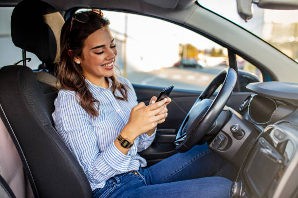 donna autista che usa uno smartphone in auto. - driving text messaging accident danger foto e immagini stock