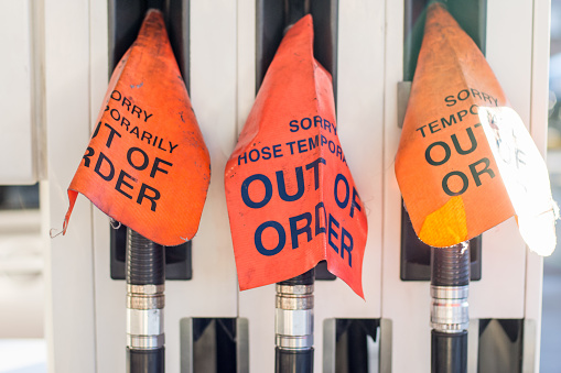 Fuel pumps with a cover signs that read -out of order- at the gasoline station. Out of order sign on petrol hoses, fuel pistols