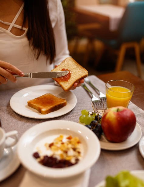 istock Young woman spreading jam on a toast 1179165317