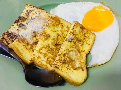 Breakfast French Toast with Fried Egg. A Dish Made of Sliced Bread Soaked in Eggs and Milk Then Fried.