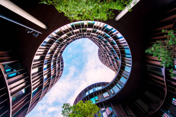 istock Abstract image of a modern building with a dynamic facade and a green tree nearby. 1179165822