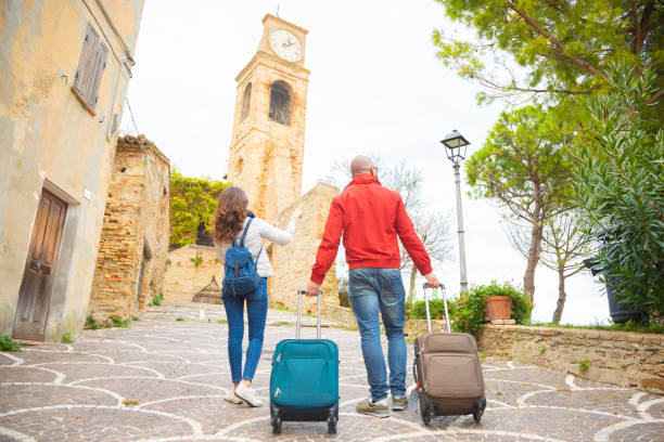 Couple traveling in Europe, looking for the right way to the hotel.View from behind Picture of tourists with luggage, rear view lombardy photos stock pictures, royalty-free photos & images