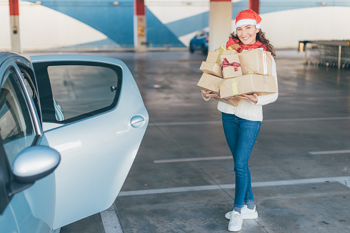 Portrait of young woman with Christmas gift in her hands