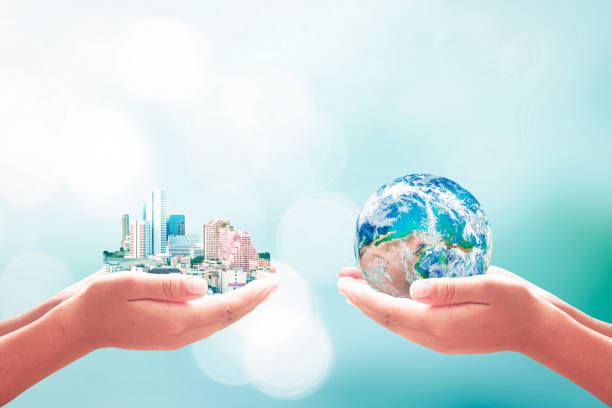 Sustainable community concept Two human hands holding earth global and big city on blurred blue nature background. Elements of this image furnished by NASA responsible business stock pictures, royalty-free photos & images